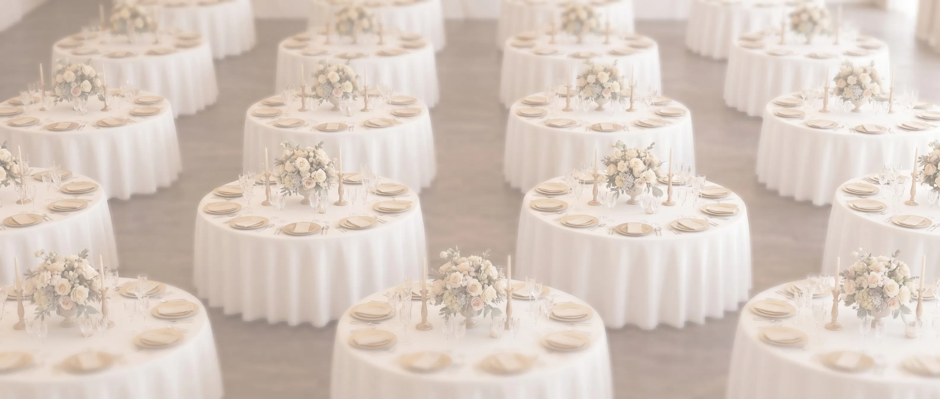Salón de recepción de boda en tonos claros con mesas montadas